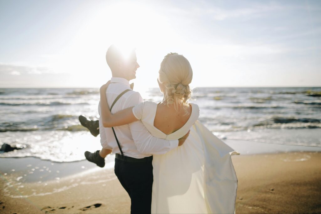 A loving couple celebrates their wedding by the sea during a beautiful sunset.